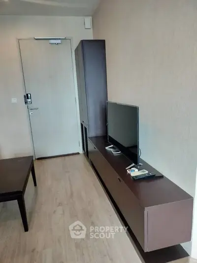 Modern living room with sleek TV unit and wooden flooring, perfect for cozy urban living.