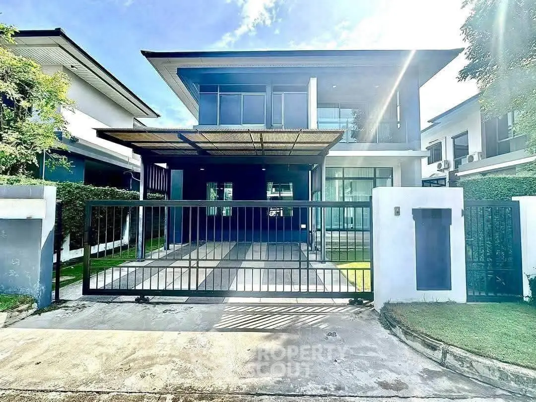 Modern two-story house with sleek design and spacious driveway in a suburban neighborhood.
