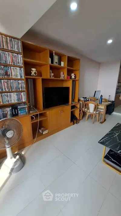 Spacious living room with built-in wooden shelves and modern decor