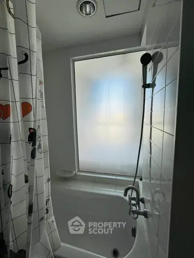 Cozy bathroom with frosted window and modern shower setup