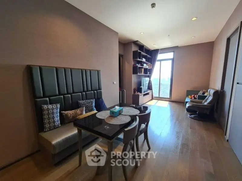 Modern living room with stylish furniture and large window offering city view