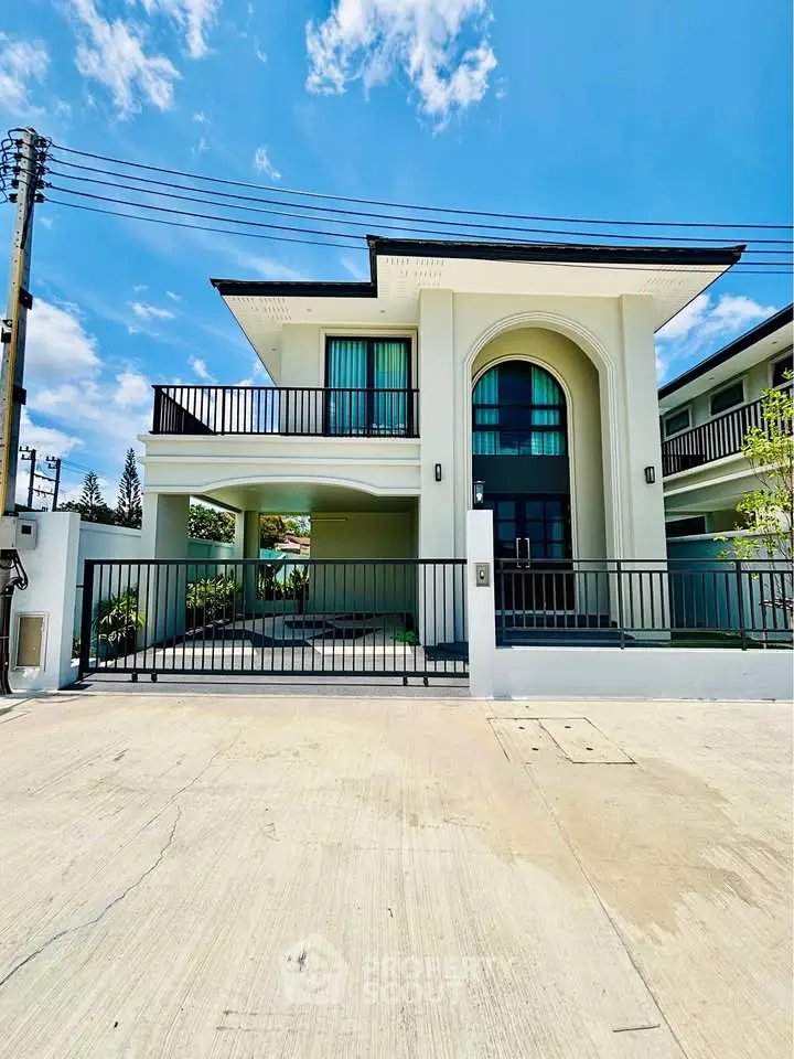 Stunning modern two-story home with spacious balcony and elegant facade under clear blue sky.