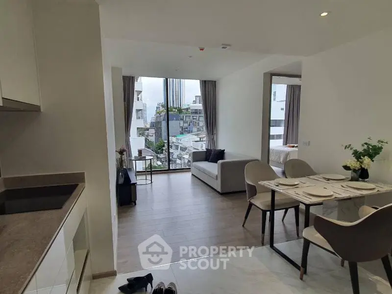 Modern open-plan living room with dining area and city view