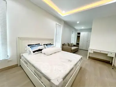 Spacious modern bedroom with elegant furnishings and ambient lighting