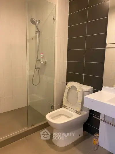 Modern bathroom with glass shower and sleek fixtures in a contemporary apartment.
