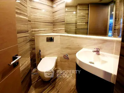Luxurious modern bathroom with elegant marble walls and sleek fixtures.