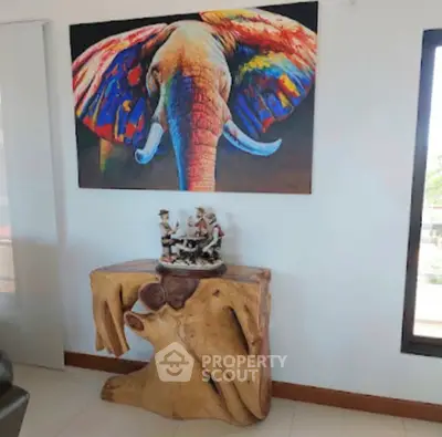 Stylish living room with vibrant elephant artwork and unique wooden console table.
