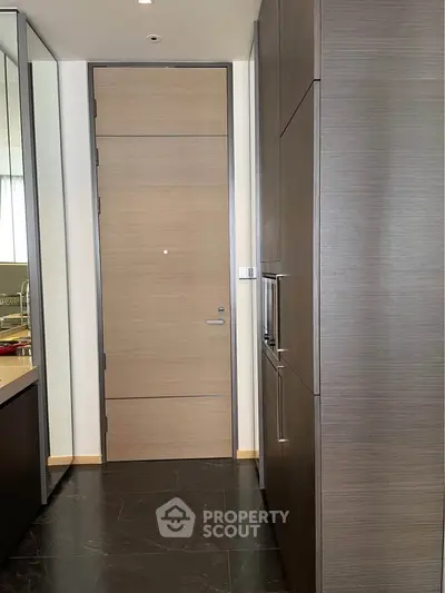 Modern kitchen with sleek cabinetry and dark flooring, featuring a closed layout and contemporary design.
