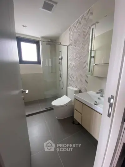 Modern bathroom with sleek design, glass shower, and stylish fixtures in a contemporary home.