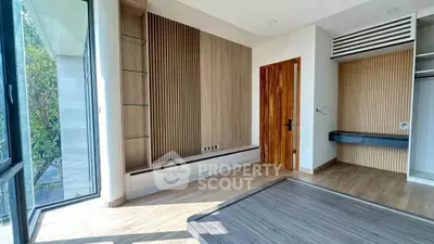 Modern bedroom with wooden accents and large windows offering natural light.