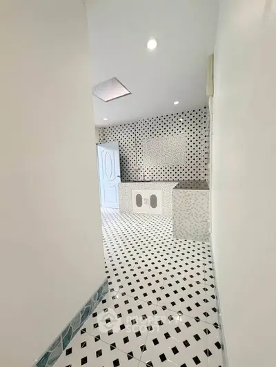 Stylish modern bathroom with black and white geometric tiles and sleek fixtures.