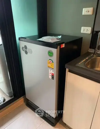 Modern kitchen with compact refrigerator and sleek cabinetry