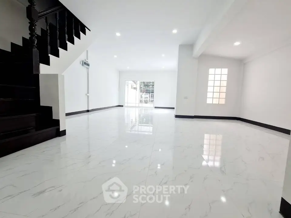 Spacious modern living room with elegant staircase and glossy marble flooring