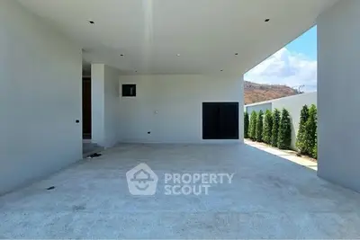 Modern minimalist exterior with spacious driveway and lush greenery