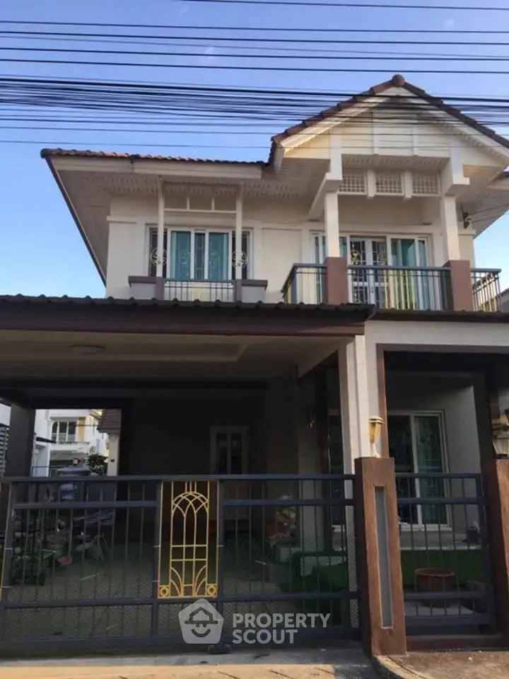 Charming two-story house with gated entrance and spacious driveway in a serene neighborhood.