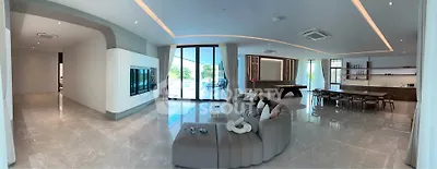 Luxurious open-plan living room with modern decor and expansive windows