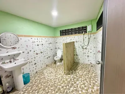 Spacious bathroom with unique tile design and open shower layout.