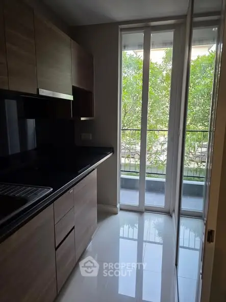 Modern kitchen with sleek cabinets and large window overlooking greenery