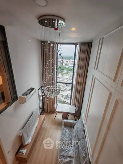 Luxurious high-ceiling living room with stunning city view and elegant chandelier