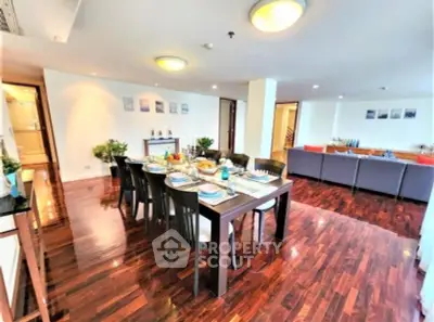 Spacious dining and living area with elegant wooden flooring and modern decor.