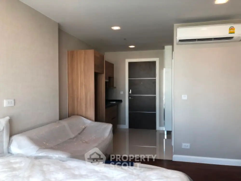 Modern bedroom with air conditioning and sleek wooden furniture in a contemporary apartment.