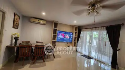 Spacious living room with modern decor and large TV, perfect for family gatherings.