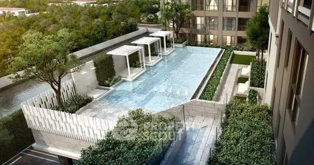 Luxurious rooftop pool with cabanas and lush greenery in modern apartment complex.