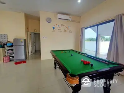 Spacious game room with pool table and modern decor in a bright home setting.