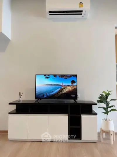Modern living room with sleek TV stand and air conditioning unit, perfect for cozy entertainment.