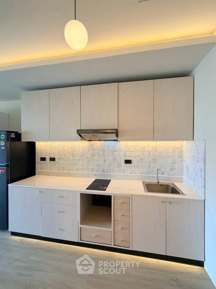 Modern kitchen with sleek cabinetry and built-in appliances in a stylish apartment.