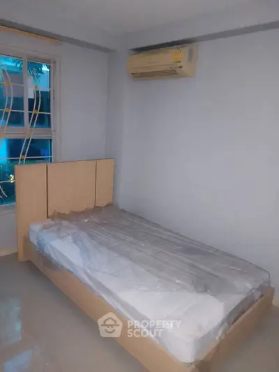 Cozy bedroom with single bed and air conditioning in modern apartment