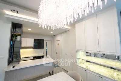 Modern kitchen with elegant chandelier and sleek cabinetry