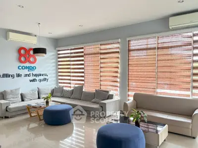 Spacious modern living room with stylish furniture and large windows in a luxury condo.