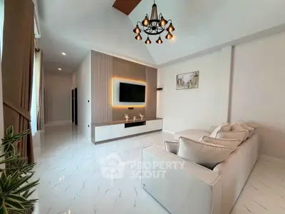 Spacious modern living room with elegant chandelier and sleek TV setup