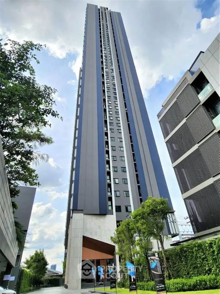 Stunning modern high-rise building with sleek design and lush greenery, perfect for urban living.