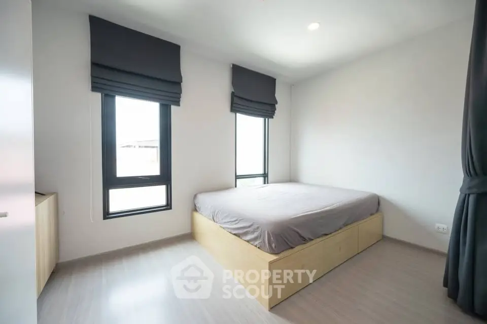 Modern minimalist bedroom with large windows and sleek design