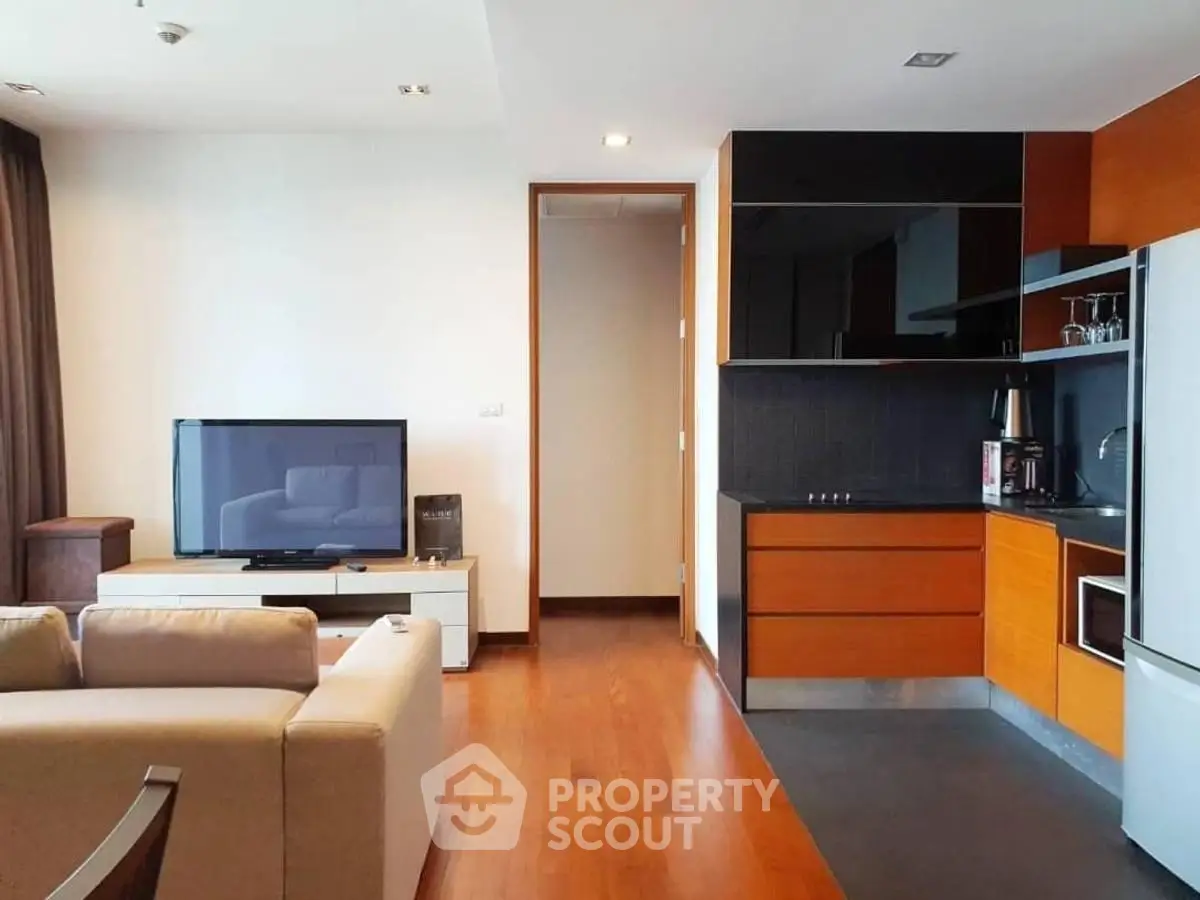 Modern open-layout living room with sleek kitchen and wooden flooring