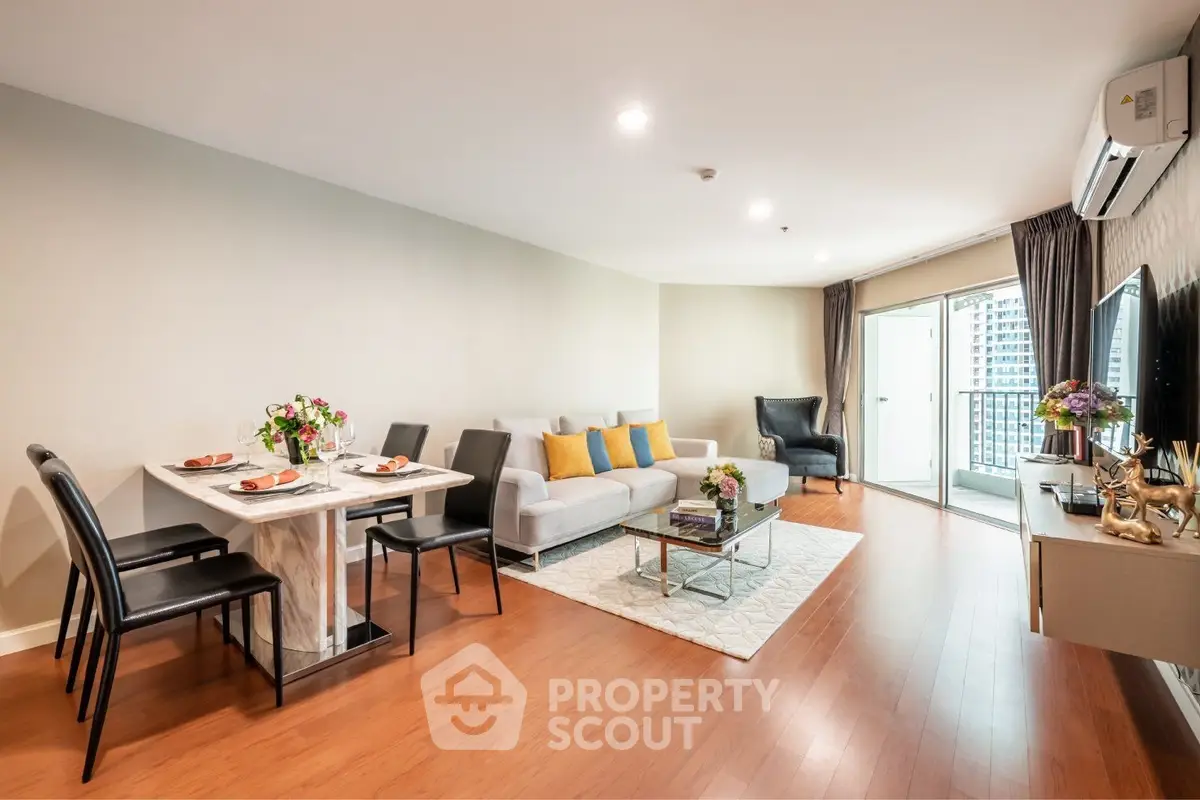 Spacious modern living room with elegant decor and balcony view in a high-rise apartment.