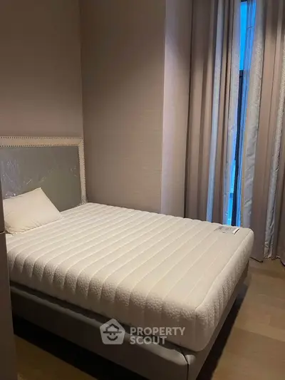 Cozy bedroom with a comfortable bed and elegant curtains, perfect for relaxation and rest.