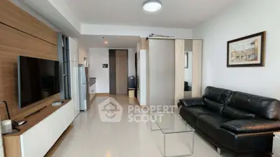 Modern living room with sleek furniture and open kitchen layout in a stylish apartment.