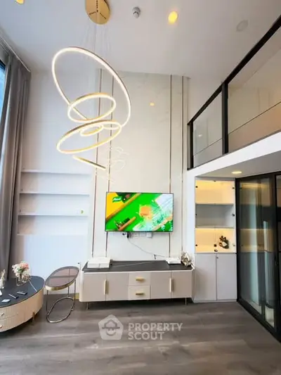 Modern living room with high ceiling, stylish lighting, and mezzanine level