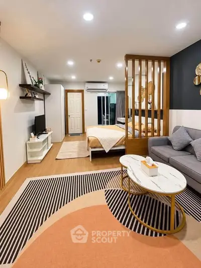 Modern studio apartment with stylish decor and open layout, featuring cozy living area and comfortable bed.