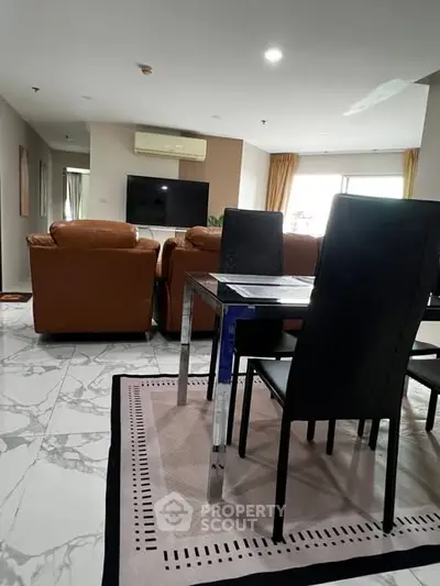 Spacious living room with modern furniture and marble flooring in a stylish apartment.