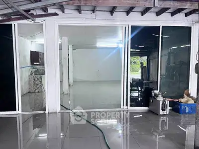 Spacious interior with glossy tiled floors and large glass doors, perfect for versatile use.