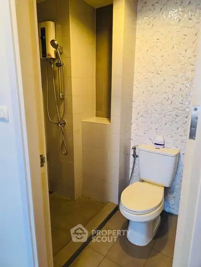 Compact bathroom with modern shower and toilet in a stylish apartment.