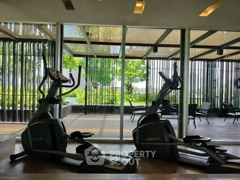Modern gym with exercise equipment and garden view