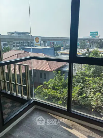 Modern apartment balcony with city view and nearby commercial buildings