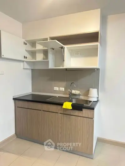 Modern kitchen with sleek cabinetry and open shelving in a compact layout.