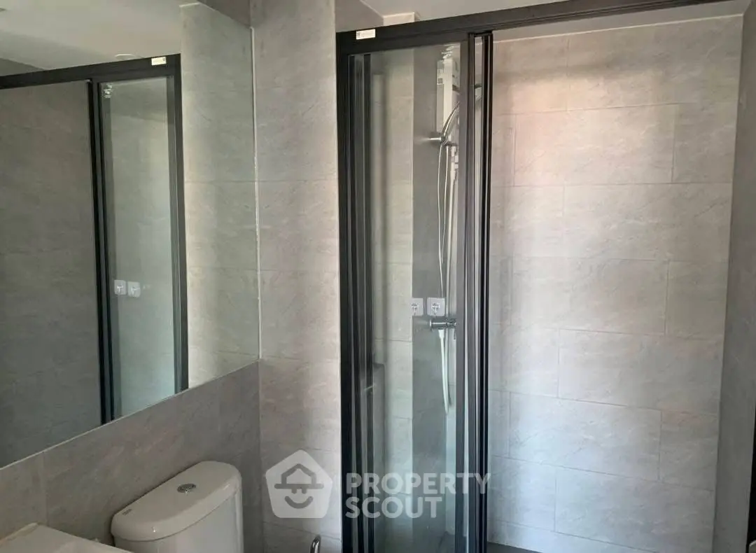 Modern bathroom with sleek shower and toilet in contemporary design.