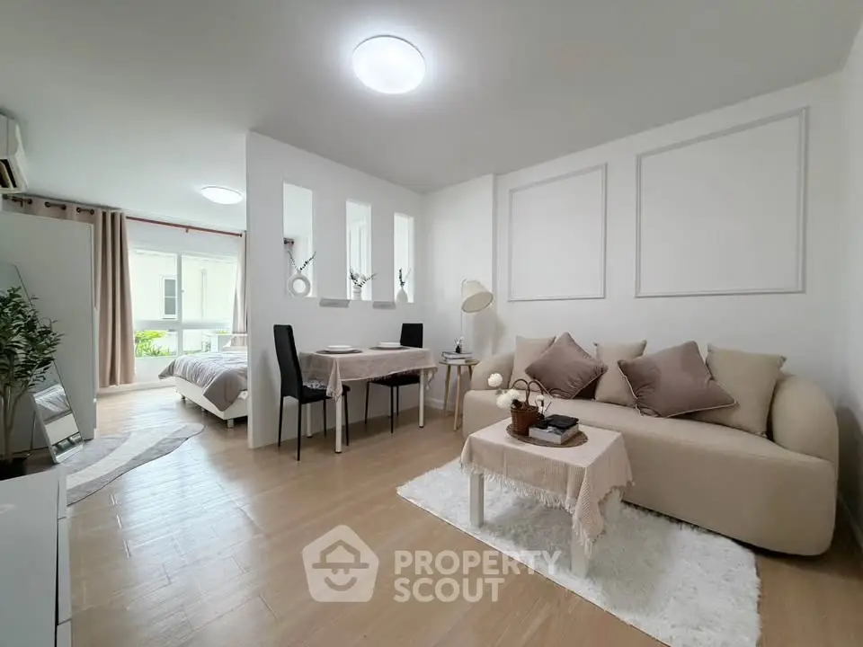 Modern open-plan living room with cozy seating and dining area, featuring elegant decor and natural light.